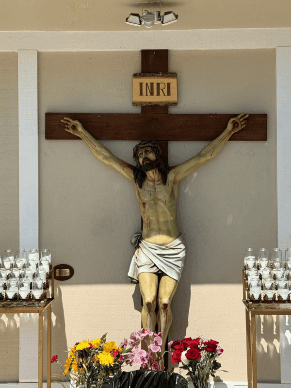 Crucifix with votive candles in the chapel