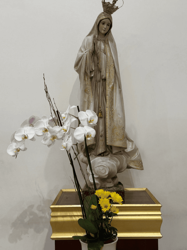 Statue of the Virgin Mary with white flowers