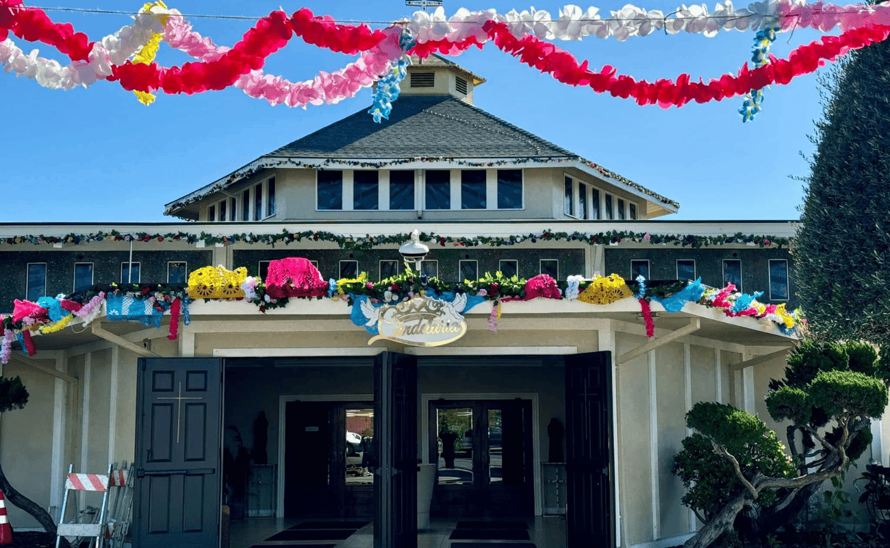 Church façade decorated with papel picado and flowers for a parish feast