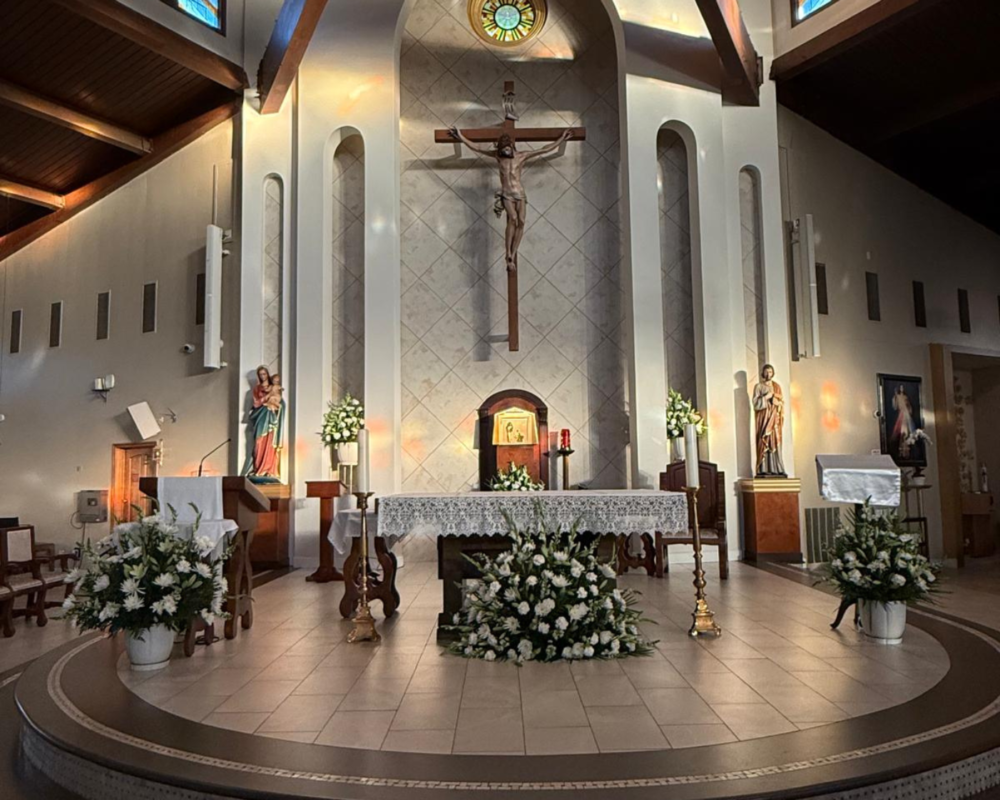 Parish altar with a crucifix and white floral arrangements